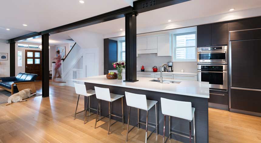 A modern kitchen renovation with an open concept with a woman coming down the stairs in Norfolk Virginia