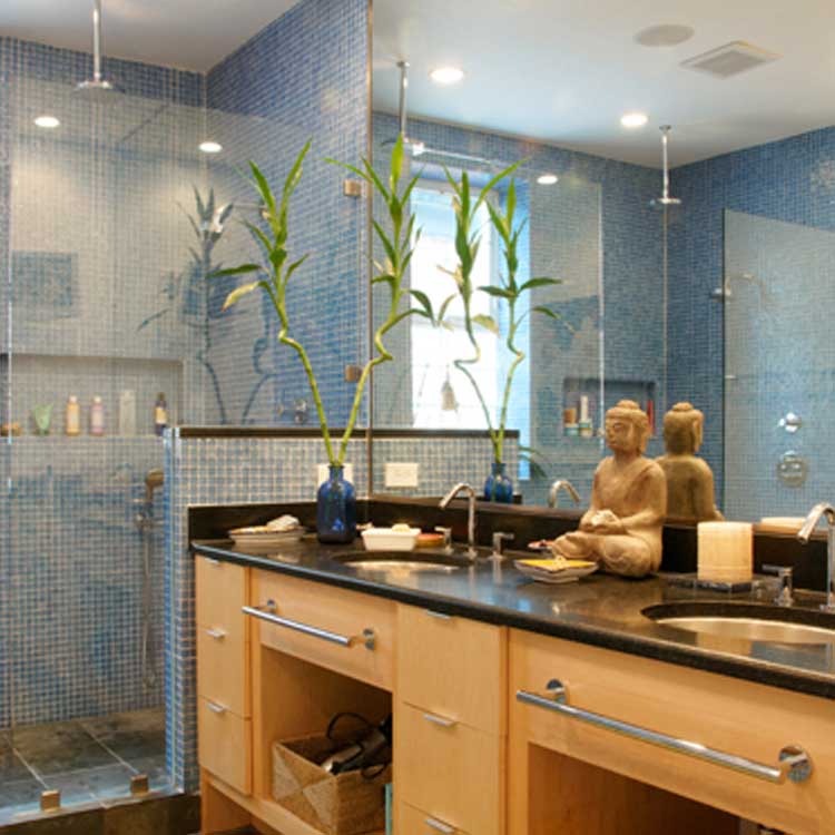 A luxury bathroom with wood cabinets and stone counter tops