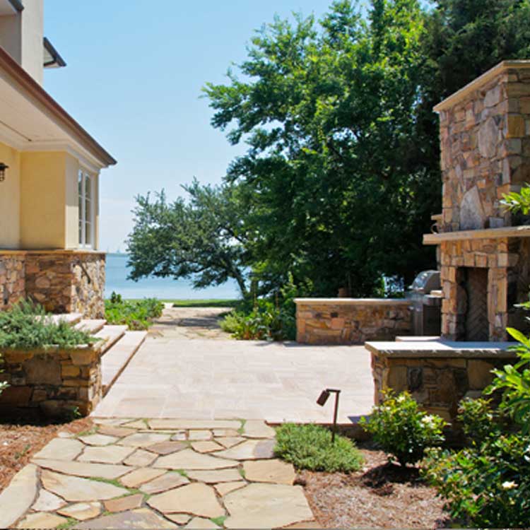 A beautiful outdoor space with a stone patio and fireplace