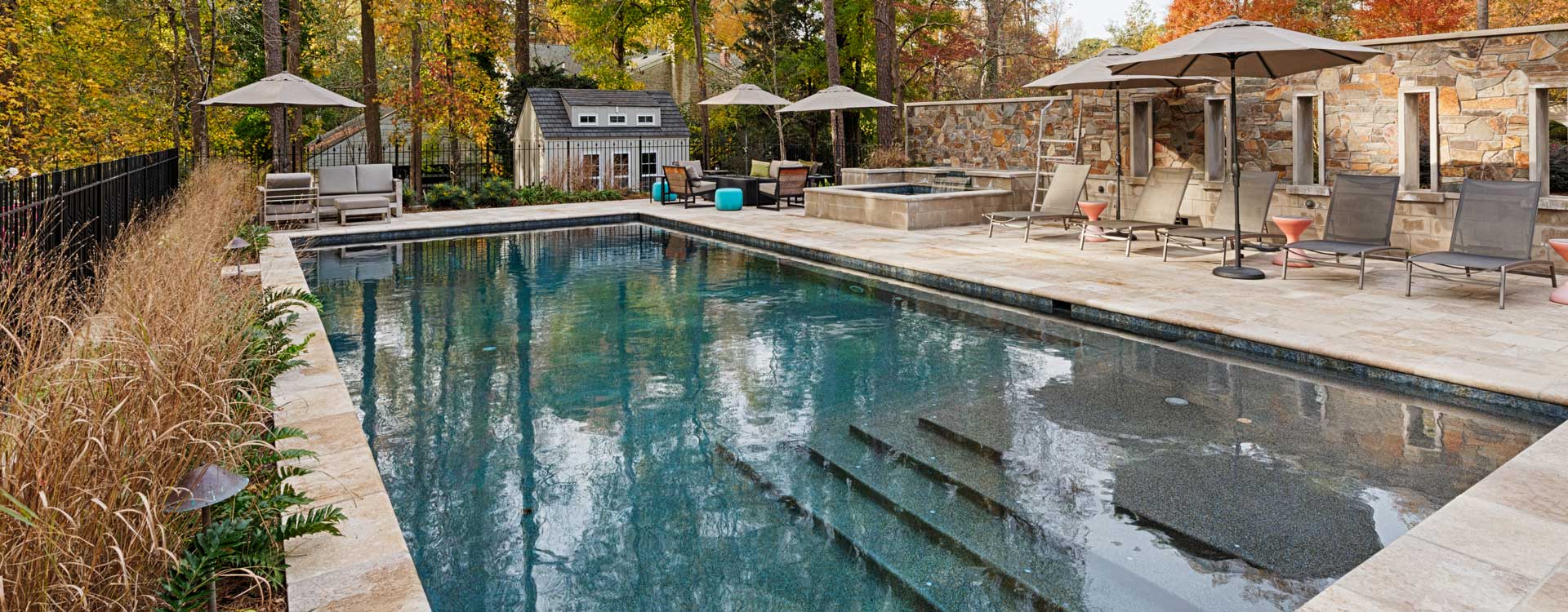 Pool renovation with blue water and outdoor furniture built by Covington Contracting luxury custom homebuilder