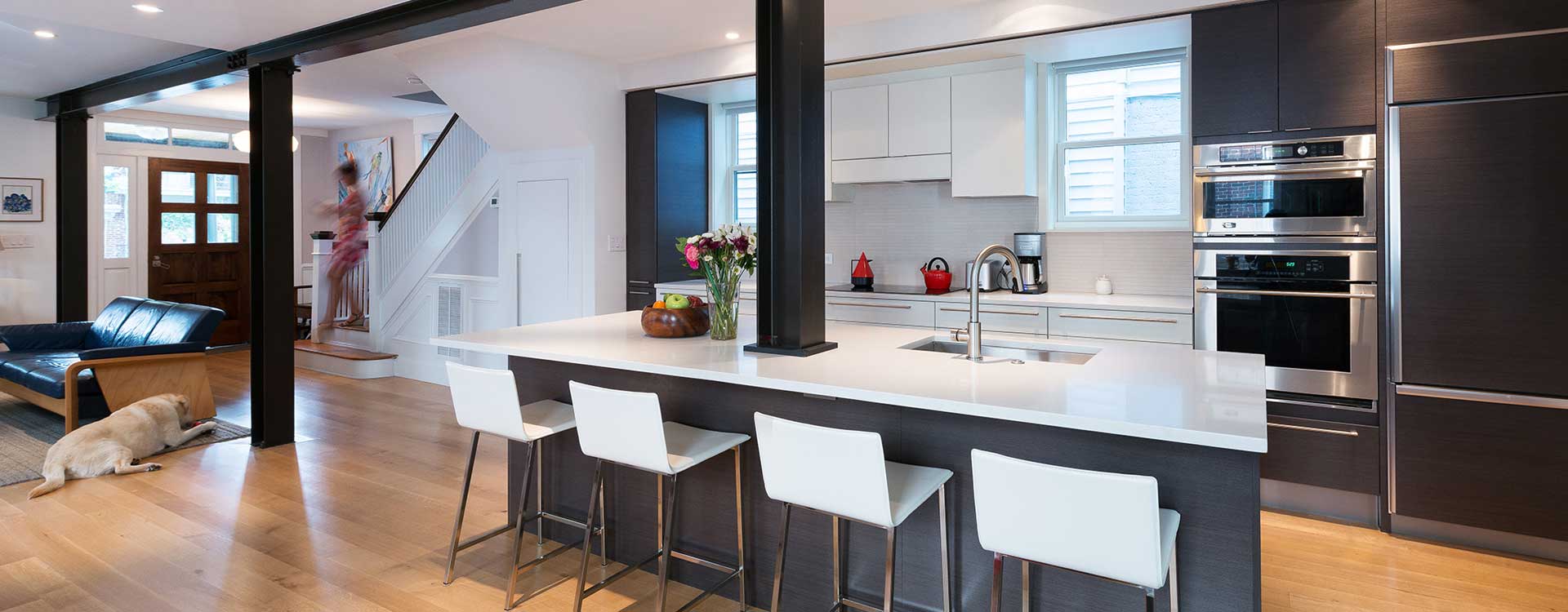 A kitchen renovation with dark cabinets and white stone counter tops built by Covington Contracting luxury custom homebuilder in Hampton Roads Virginia